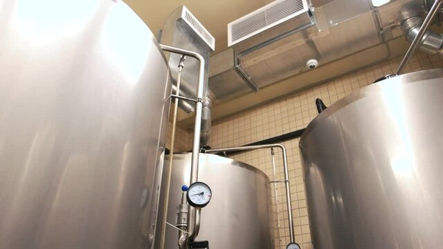 Micro brewery fermenting vessels. Up view beer plant with brewing kettles, vessels, and ventilation.