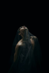 Pray. Graceful classic ballet male dancer isolated on white studio background. Man in minimalistic black cloth looks graceful, inspired. The grace, artist, movement, action and motion concept.