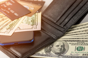 Phone, wallet with money and credit cards, close-up.