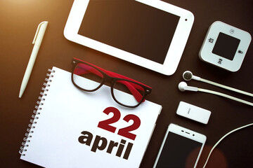 April 22nd. Day 22 of month, Calendar date. Office workplace with laptop, notebook, office supplies...