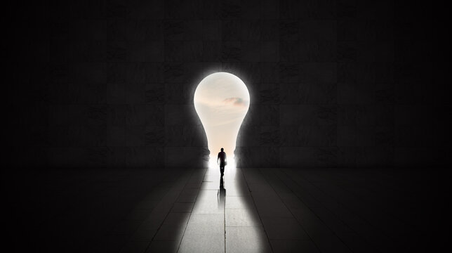 man walking  through an open lightbulb door to the financial freedom. Light bulb innovative idea concept 