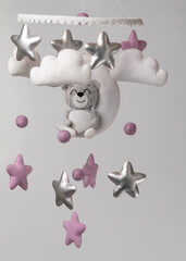 Baby crib mobile - kids toys, on light background.