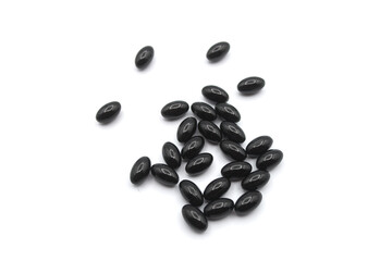Closeup of black pills of coal on white background - 398065489