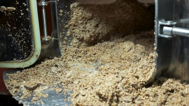 Digging brewery waste from tank. Collection of waste malt after brewing beer at the brewhouse.