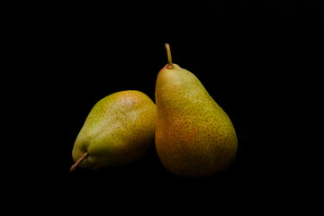 Two ripe pears on black background