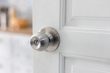 Door with grill, stainless door knob or handle on wooden door in beautiful lighting.a handle on a...