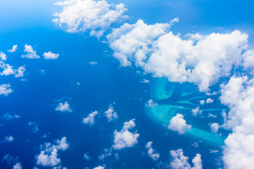 Fototapeta na wymiar Airial view through the clouds on the island of the Maldives archipelago in the Indian ocean