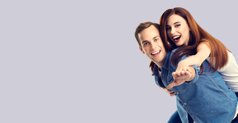 Obraz premium Love, relationship, dating, lovers, sales, romantic concept - happy excited couple, man and woman in piggyback pose, isolated over grey background. Copy space for text.