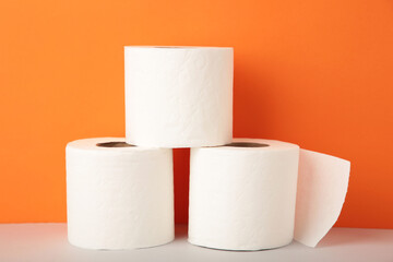 Toilet paper on orange background with copy space