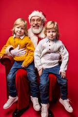 santa claus with children, mature santa congratulating kids with happy new year, x-mas, isolated on red background