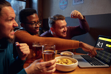 Winners. Excited fans in bar with beer and mobile app for betting, score on their devices. Screen with match results, emotional friends cheering. Gambling, sport, finance, modern techn concept.