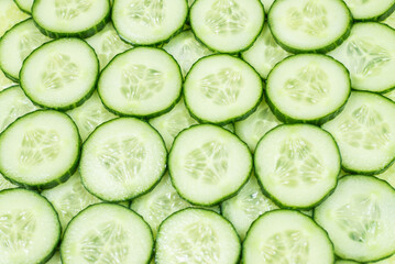 Fresh green slices of cucumber as background.