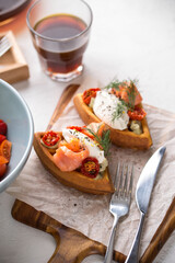 Waffles with salmon, tomato and cream cheese curd on white background