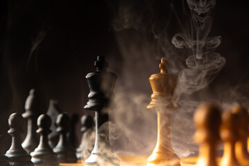 Chess pieces on the board with smoke, low key images, shallow depth of field, selective focus.