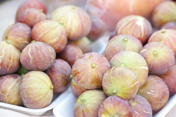 Ripe figs for sale at farmers market. Background of ripe juicy figs at market stall. Delicious healthy fruit.