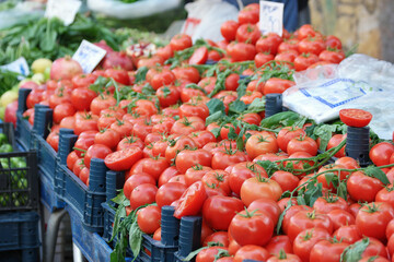 Boxes with red tomatoes at market stall. Organic vegetables at farmers market. Eco food concept.