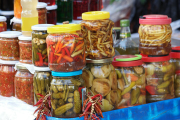 Assorted homemade vegetables preservation in glass jars. Preserved food in glass jars. Homemade preserves market.