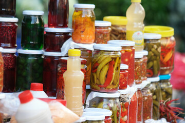Canned food in glass jars at market. Homemade preserves market.