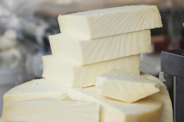 Chunks of Parmesan cheese at outdoor market. Organic French cheese on shop counter. Tasty dairy product on sale.