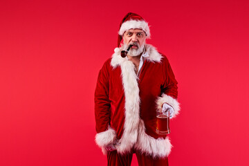 santa claus with smoking pipe in mouth look at camera, after hard party. isolated red background