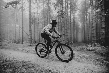 Fototapeta na wymiar Young man biking through autumn forest