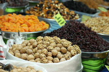 Ripe organic walnuts at farmers market. Market stall with various healthy fruits and vegetable.