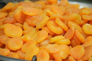 Heap of dried apricot fruits close up. Delicious dried apricots background. Healthy natural food.
