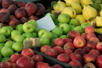 Assotment of fresh apples at farmers market. Variety of organic fruits at market stall. Healthy food concept.