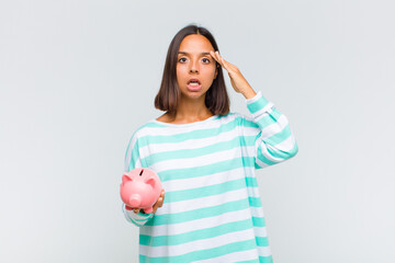 young hispanic woman looking happy, astonished and surprised, smiling and realizing amazing and...