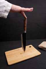 The chef holds a knife in his hand