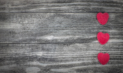 Three pink marmalade hearts on the gray wooden background, copy space, top view, minimalism. Love, romantic background