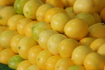 Display of lemons at fruits market. Ripe organic lemons texture. Rich with vitamins.