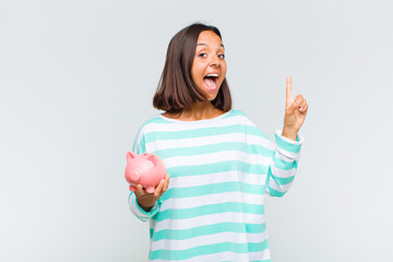young hispanic woman feeling like a happy and excited genius after realizing an idea, cheerfully...