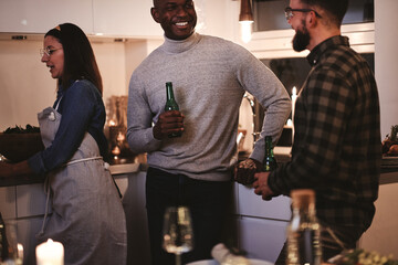 Friends laughing and talking over drinks at a dinner party