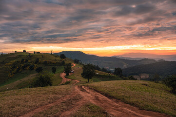 Obraz premium Sunrise on farmland hill with colorful sky and tourists camping on vacation in national park