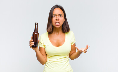 young hispanic woman looking angry, annoyed and frustrated screaming wtf or what’s wrong with you