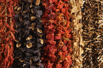 Assortment of dried vegetables at farmers market. Multicolored vegetables hanging at outdoor market.