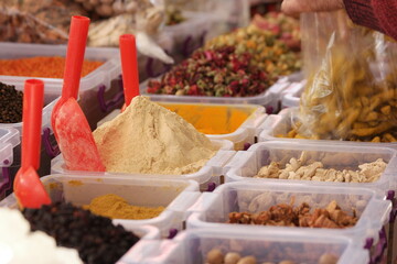 Various oriental spices in plastic boxes. Market stall with variety of colorful seasonings....