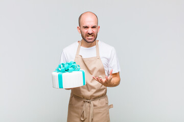 young bald man looking angry, annoyed and frustrated screaming wtf or what’s wrong with you