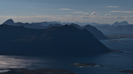 Fototapeta premium Beautiful aerial panorama view over the rugged mountains and fjords of Lofoten, a chain of islands in northern Norway, on sunny summer day with few clouds viewed from Matmora peak.