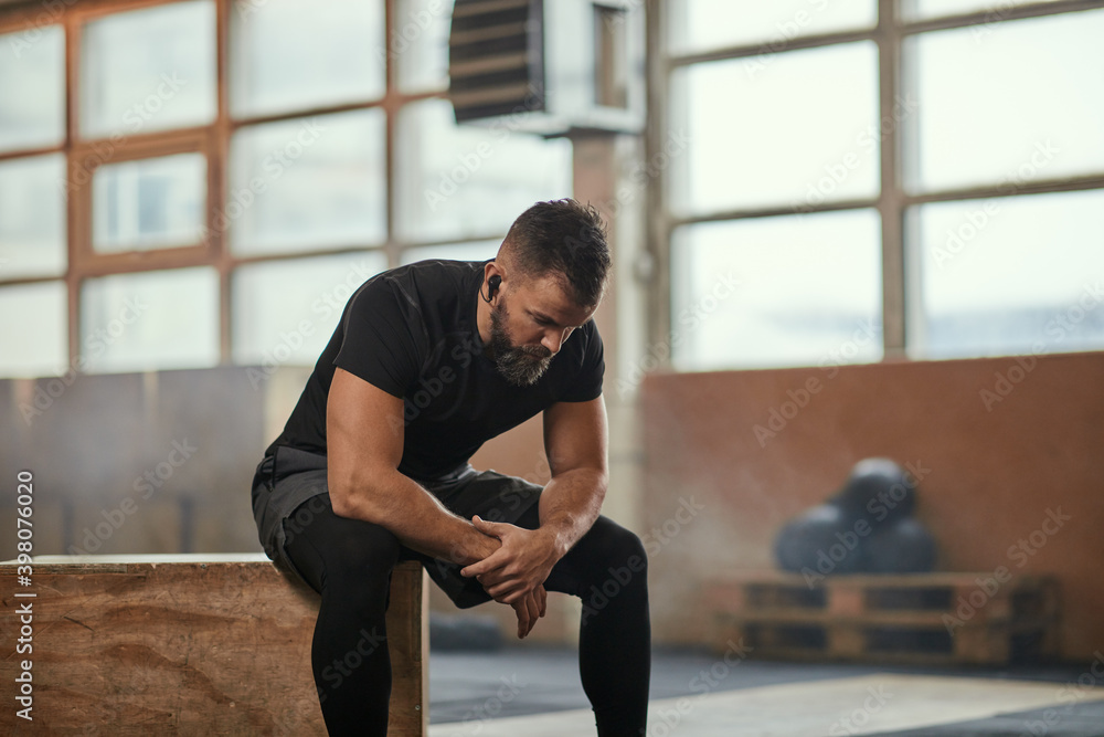 Canvas Prints Bearded sportsman resting during workout in gym