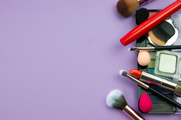lots of makeup on a purple background with space for writing