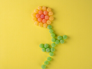 Gummy candy, arrangement of gummy candy in the shape of a flower on a colored surface. selective...