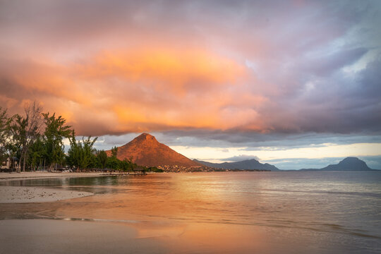 Flic en Flac beach with luxury hotels and palm trees at sunset, behind the mountain Tourelle du Tamarin, Mauritius, Africa