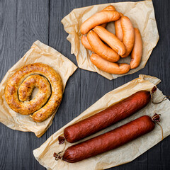 Different types of natural sausages on a wooden background.