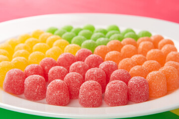 Gummy candy, arrangement of gummy candy seen in detail arranged by color on a white plate on a...