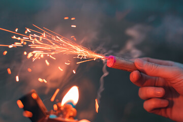 Young Man Lighting Up Firecracker in his Hand Using Gasoline Lighter. Guy Getting Ready for New...