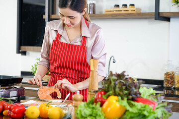 Asian beautiful woman cooking organic meal fish in kitchen 