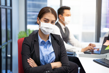 Portrait of confident businesswoman in modern office with face mask.