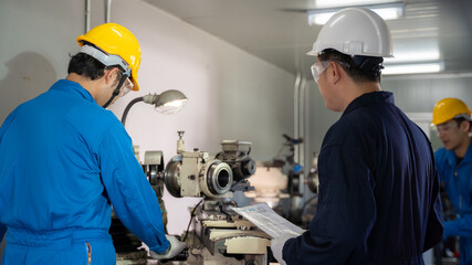 Leader inspect mechanic operating lathe grinding machine at factory.